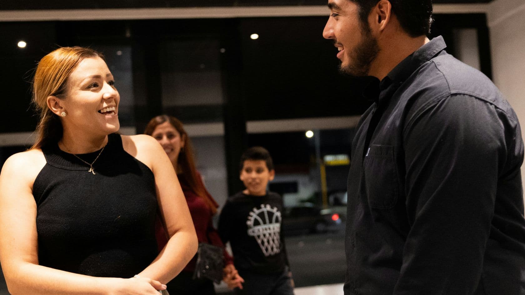 A community member reading an email newsletter on a device in a warm indoor setting.