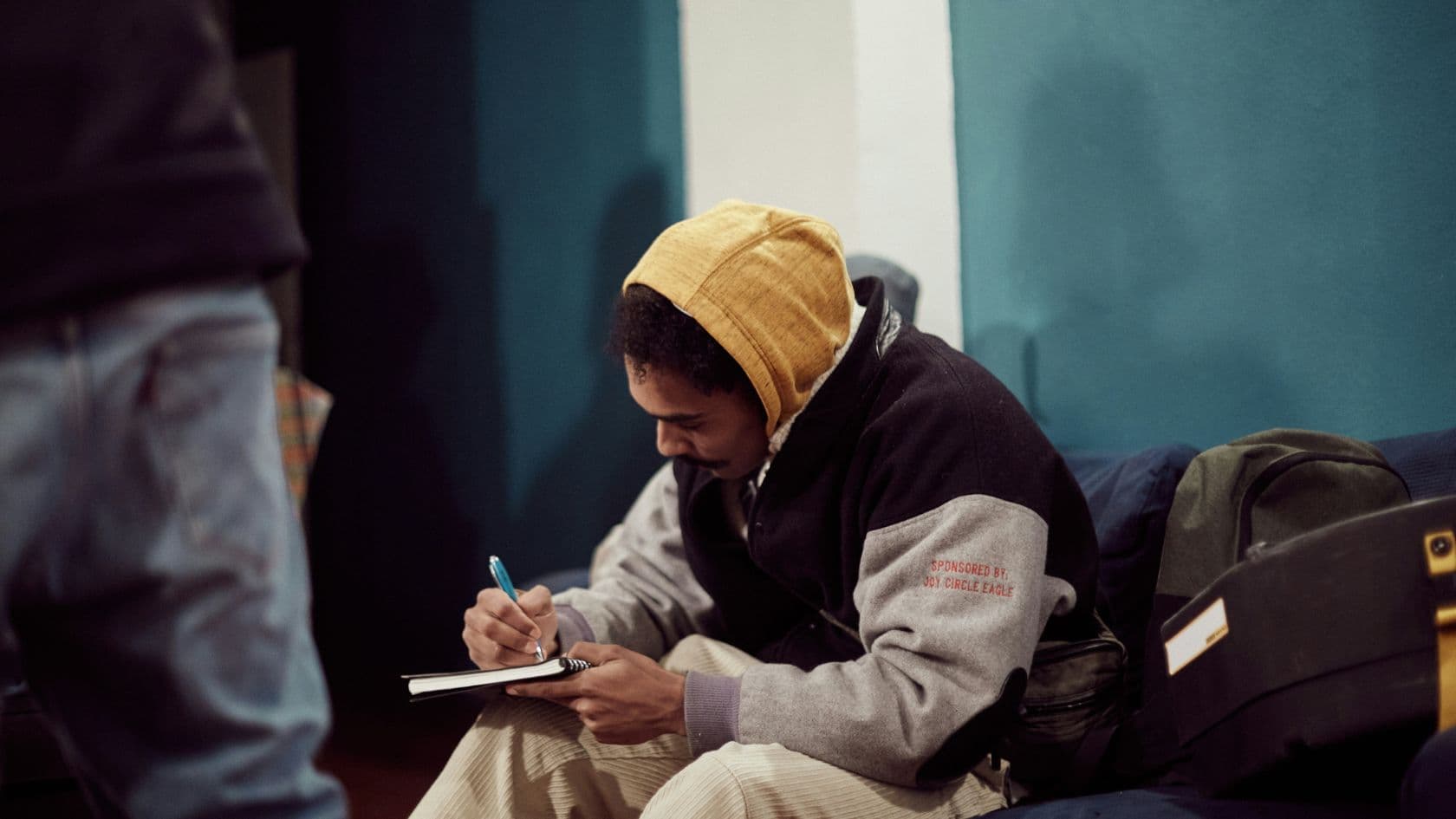 A participant writing in a notebook during a Mind Over Media community session.